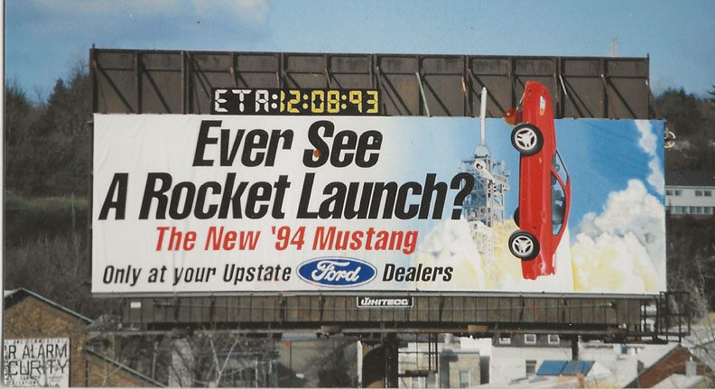 A billboard with an image of a rocket launch.